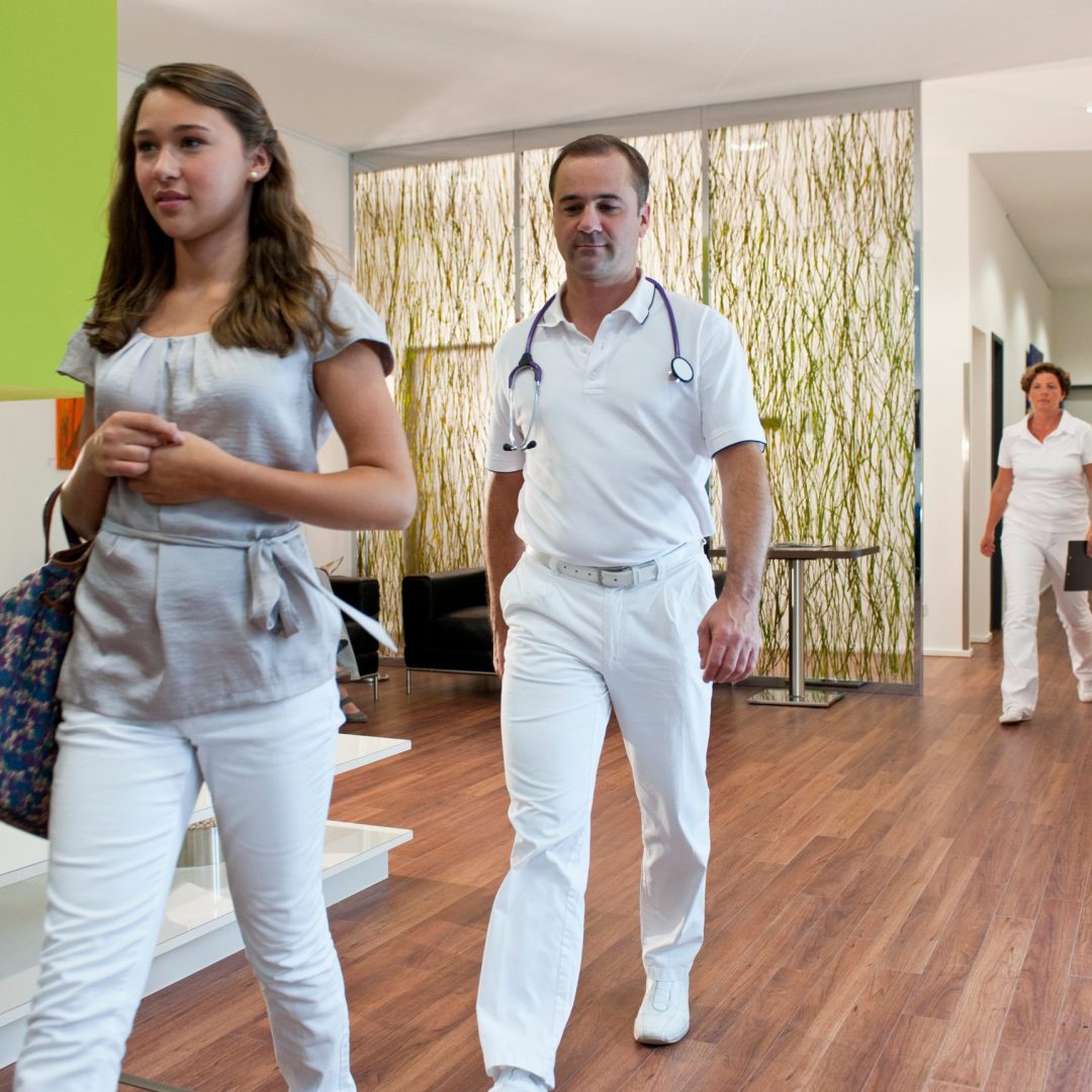 doctor-walking-with-teenage-patient-in-doctor-s-of-2026-03-26-09-46-25-utc